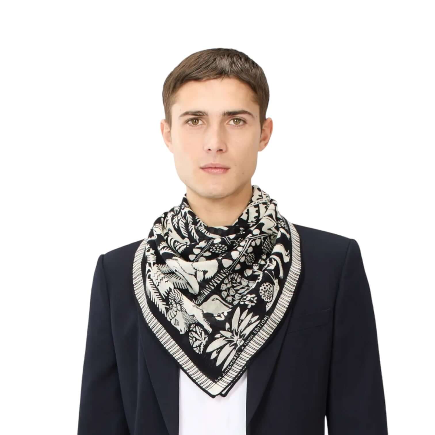 Man wearing the Foulard Quadrato Ludwig Nero scarf with unique hand-drawn designs, enhancing a stylish outfit.