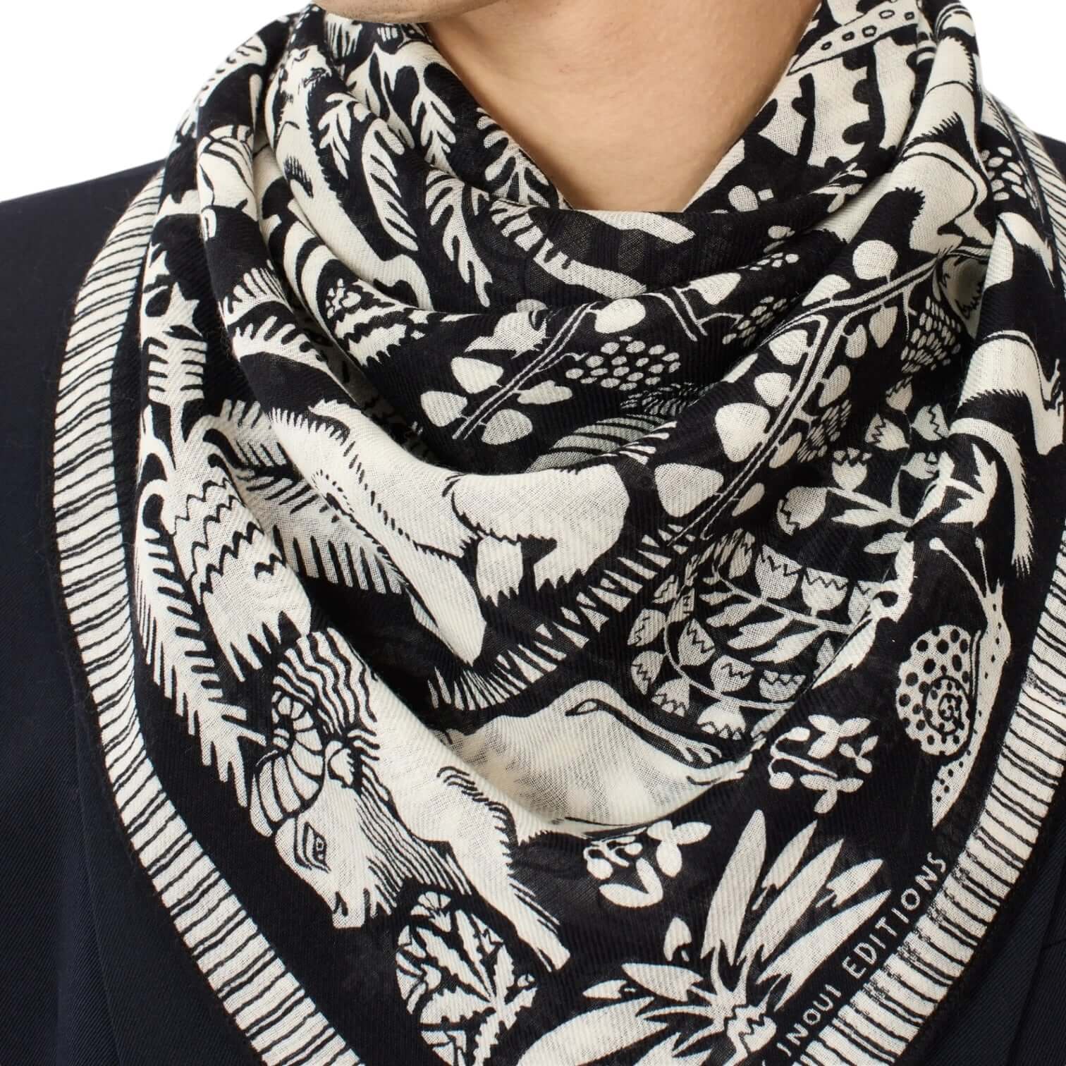 Foulard Quadrato Ludwig Nero in bianco e nero, decorato con disegni unici, indossato come sciarpa elegante.