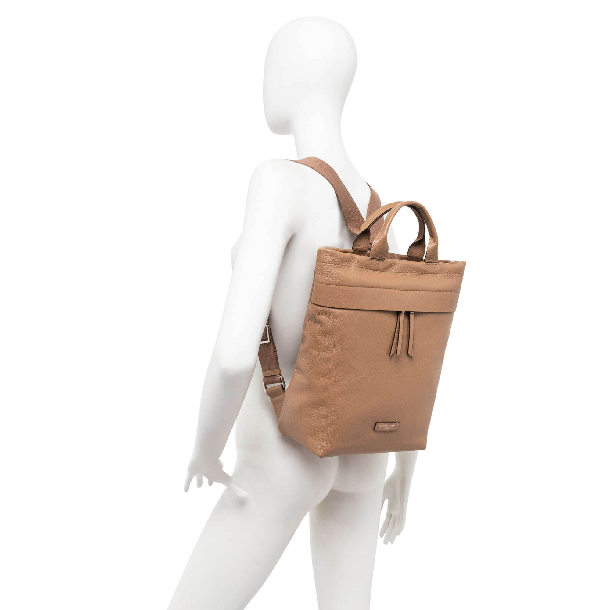 Sporty leather backpack Andrea displayed on a mannequin, featuring adjustable straps and top handles, in tan color.
