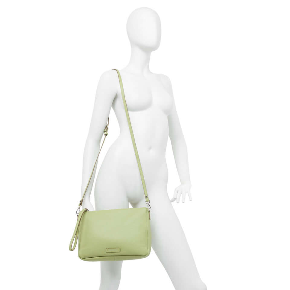 Nora Pouch by Gianni Chiarini in light green, featuring adjustable strap and zip closure, displayed on a mannequin.