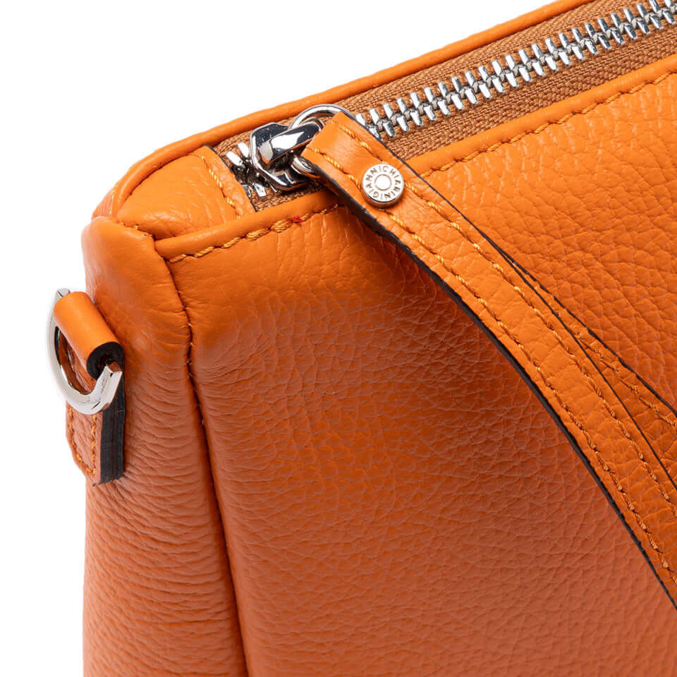 Close-up of the orange Nora Pouch by Gianni Chiarini, featuring a textured leather finish and zip closure.