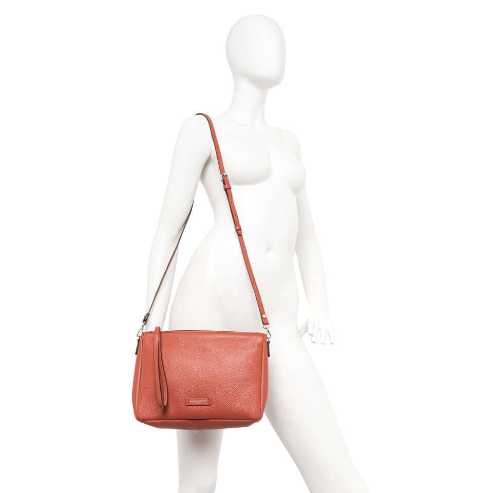 Nora Pouch by Gianni Chiarini, soft hammered leather bag with removable strap, shown in rust color on mannequin.