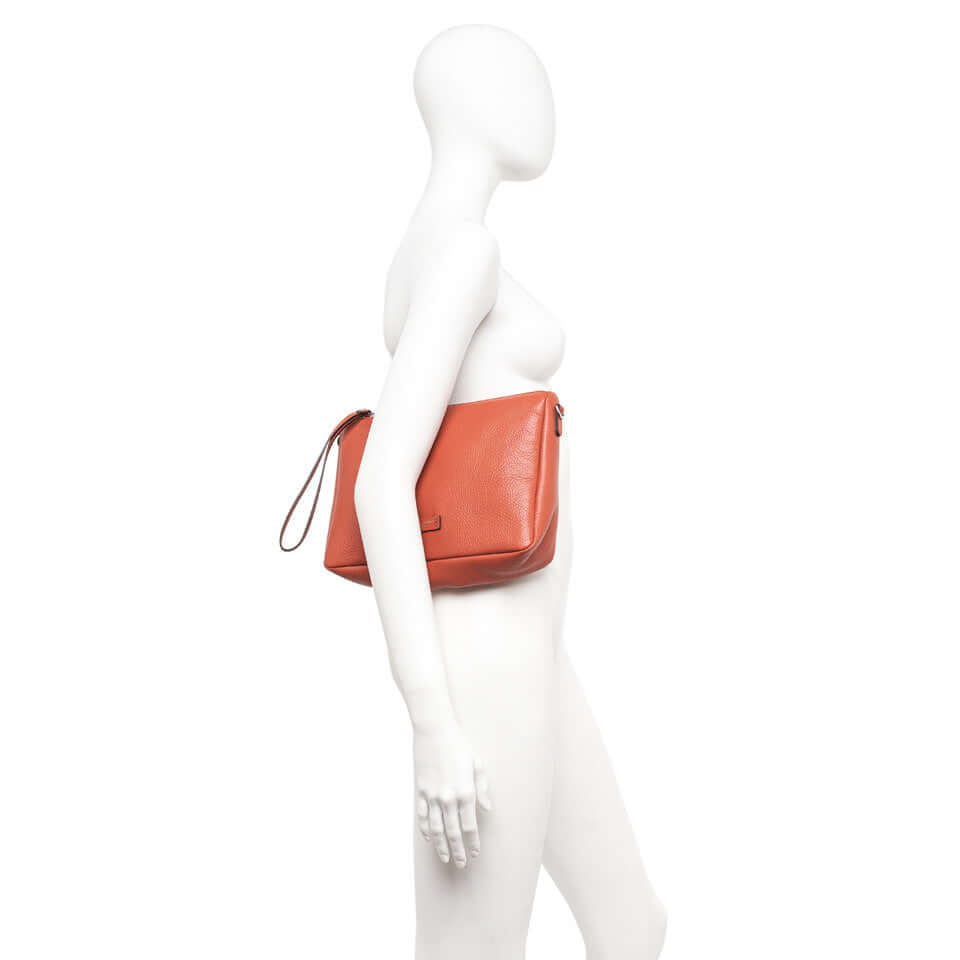 Side view of NORA POUCH by Gianni Chiarini, showcasing soft leather and removable wrist strap.