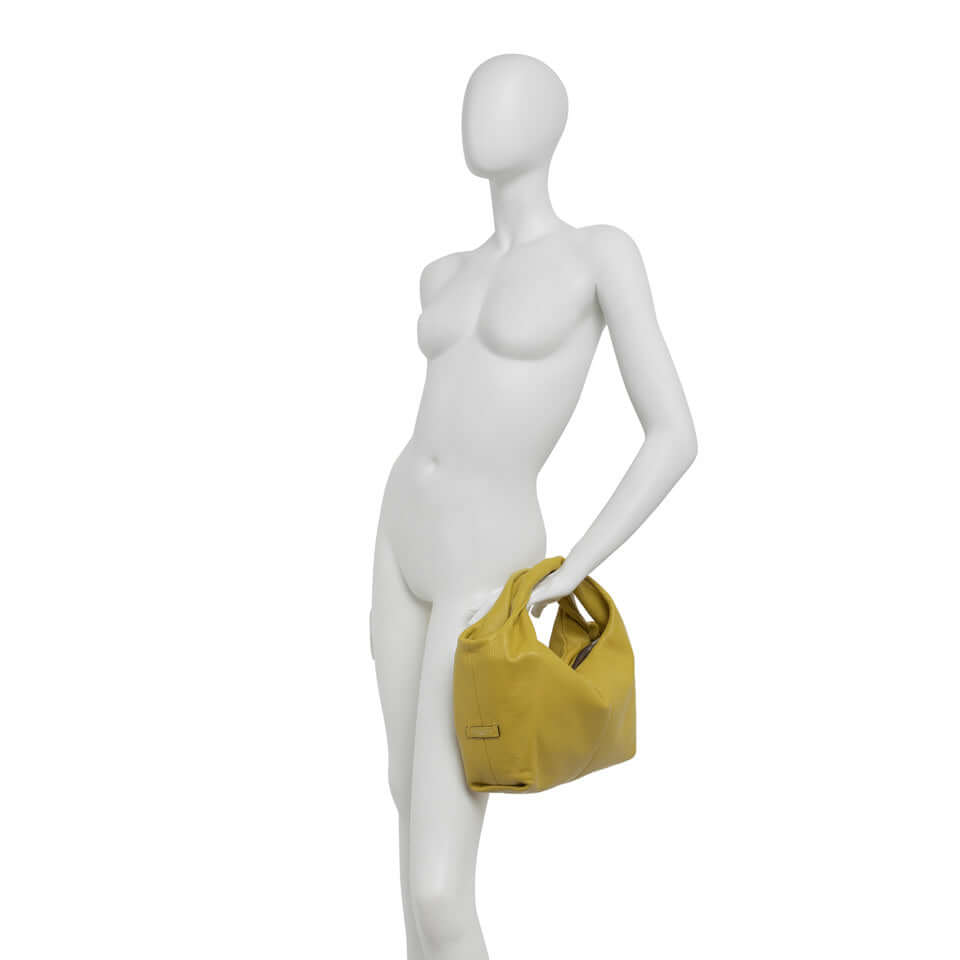 Agnese medium-sized handbag with double handles in yellow grana dollaro, displayed on a mannequin.