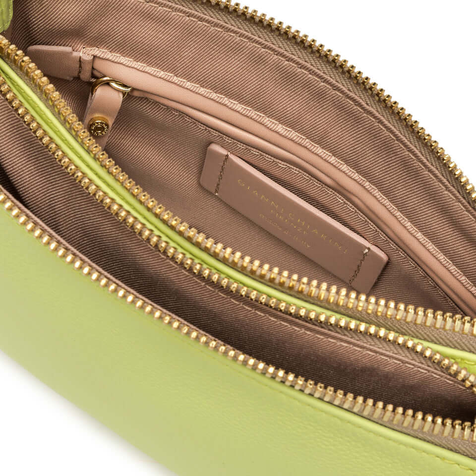 Interior view of the Frida green leather crossbody bag, showcasing spacious compartments and zipper details.