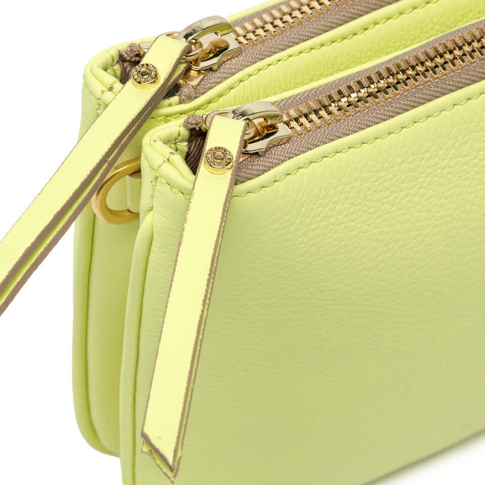 Detail of Frida crossbody bag zippers in soft matte lime leather, showcasing contemporary design and elegance.