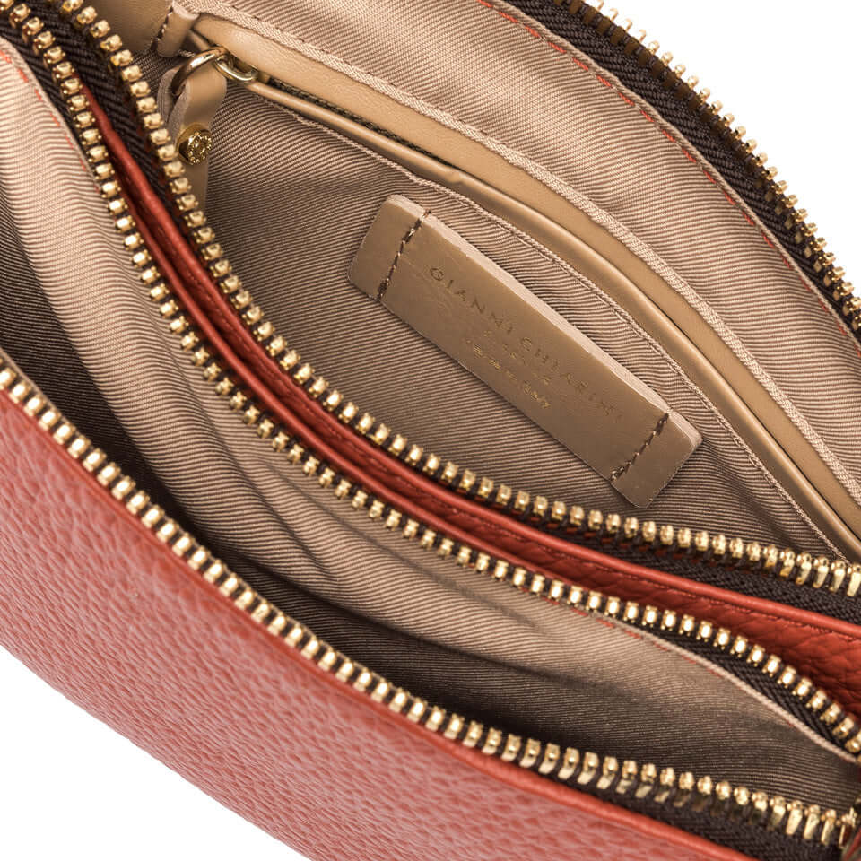 Interior view of Frida handbag featuring multiple zippered compartments and gold hardware.