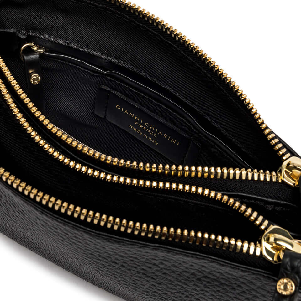 Interior view of the Frida crossbody bag, featuring gold zippers and spacious compartments.