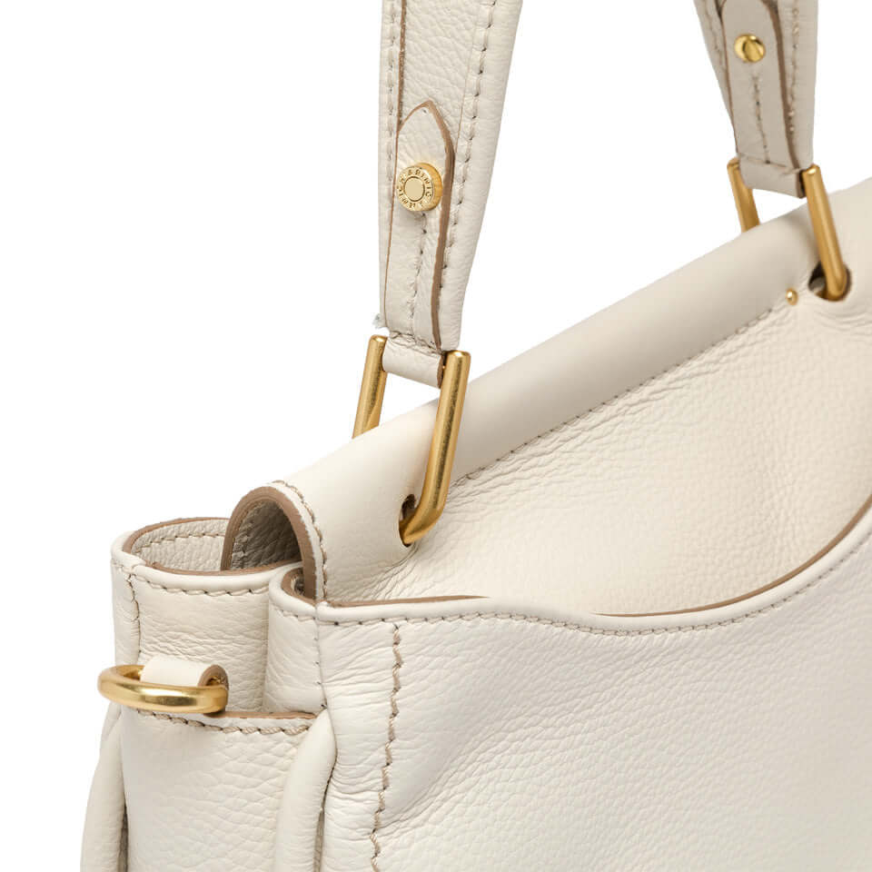 Marea handbag detail in soft leather with gold accents, featuring top handle for versatile daily and night wear.