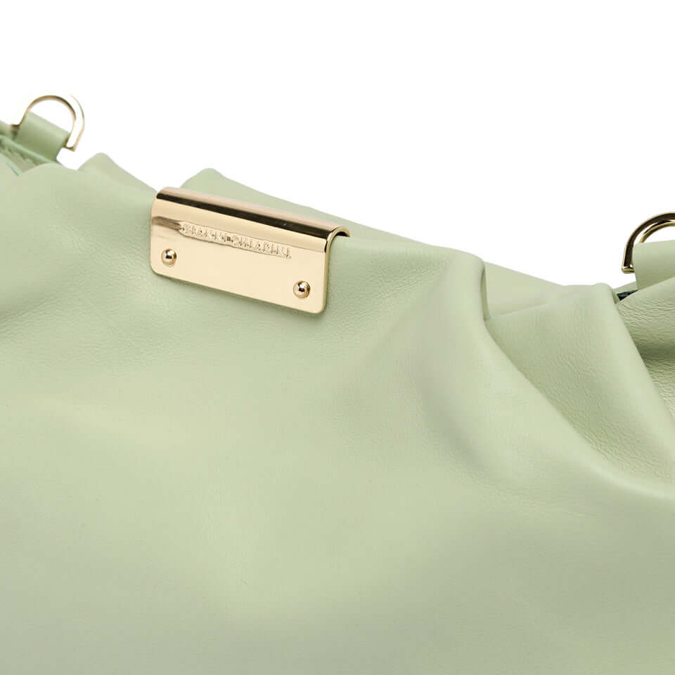 Close-up of the Perla bag showcasing the smooth mint green leather and embossed logo plate.