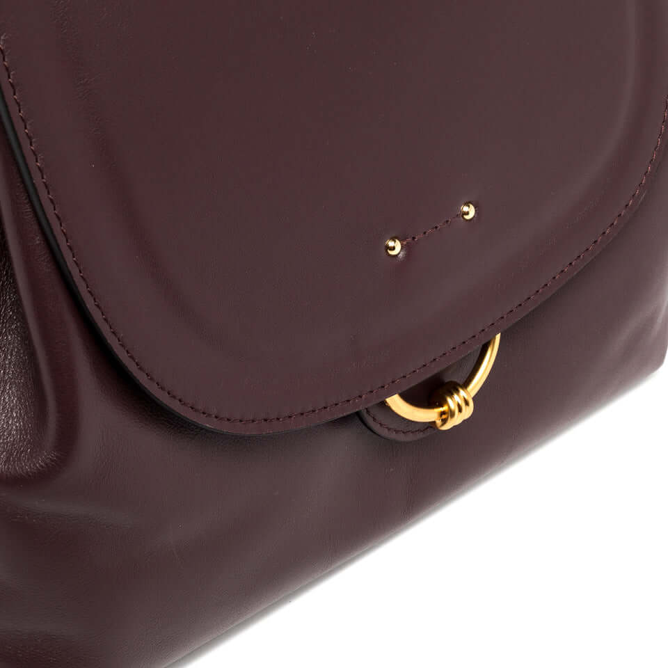 Close-up of Marlene handbag by Gianni Chiarini featuring a smooth leather finish, gold ring detail, and flap closure.