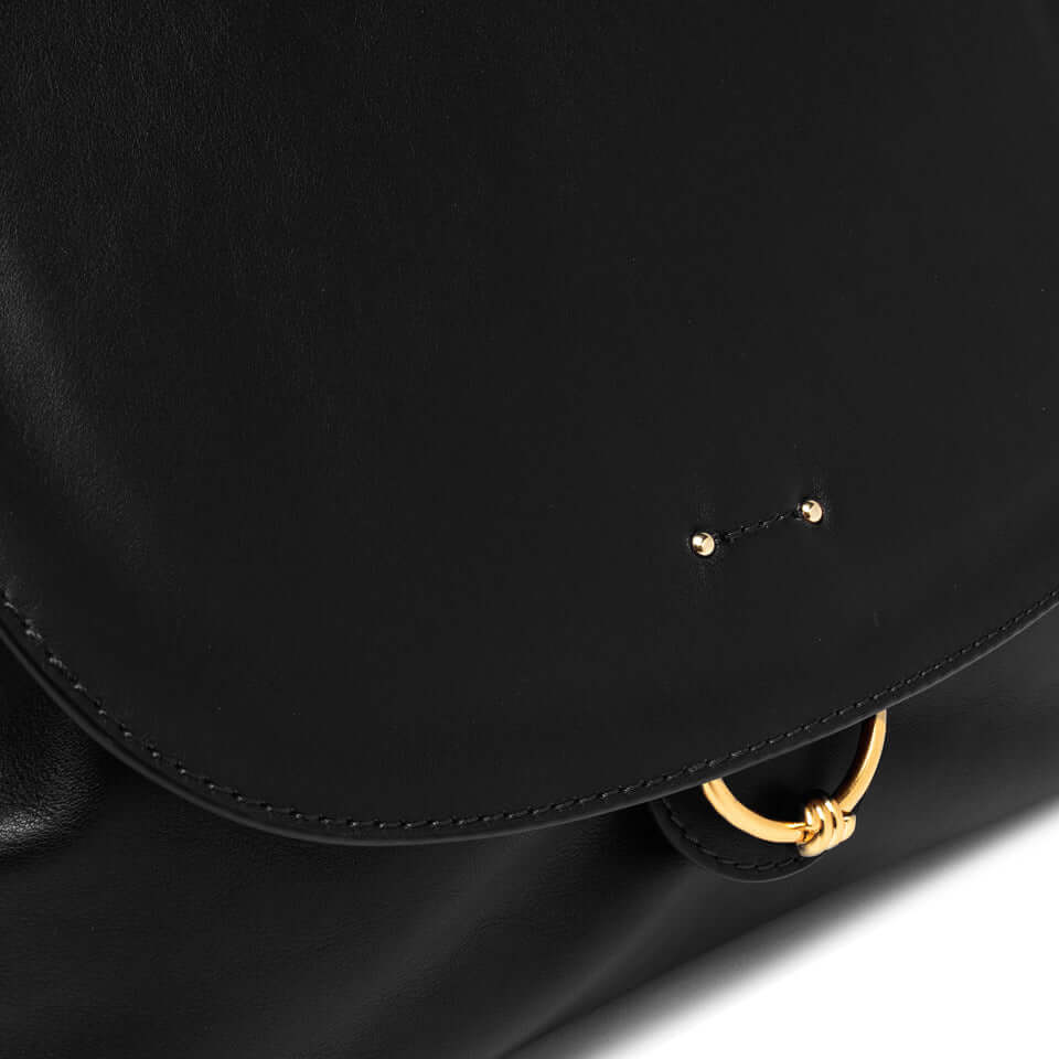 Close-up of Marlene handbag by Gianni Chiarini, featuring a smooth black leather surface and a gold ring detail.