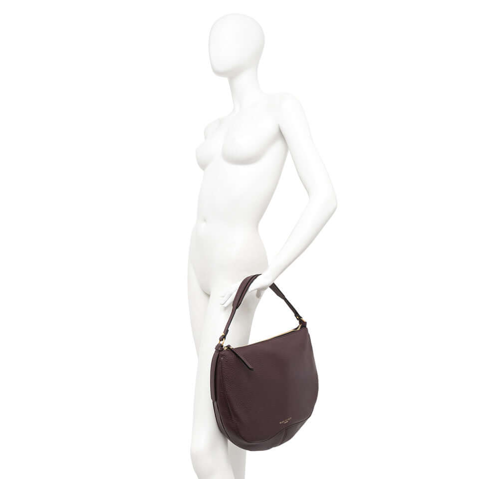 Chiara handbag in dark brown leather, vintage style with a wavy bottom, featuring a removable shoulder strap.