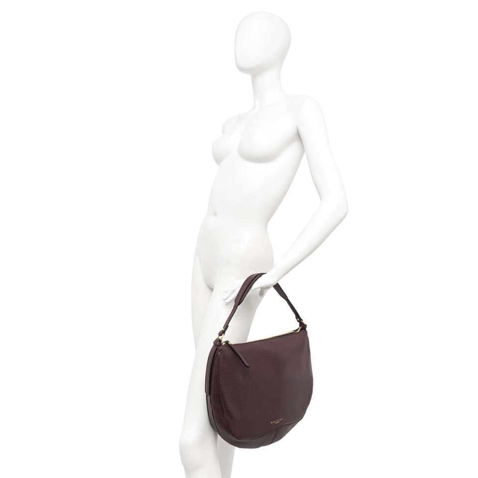 Chiara handbag in dark brown leather displayed on a mannequin, featuring a vintage design and versatile carrying options.