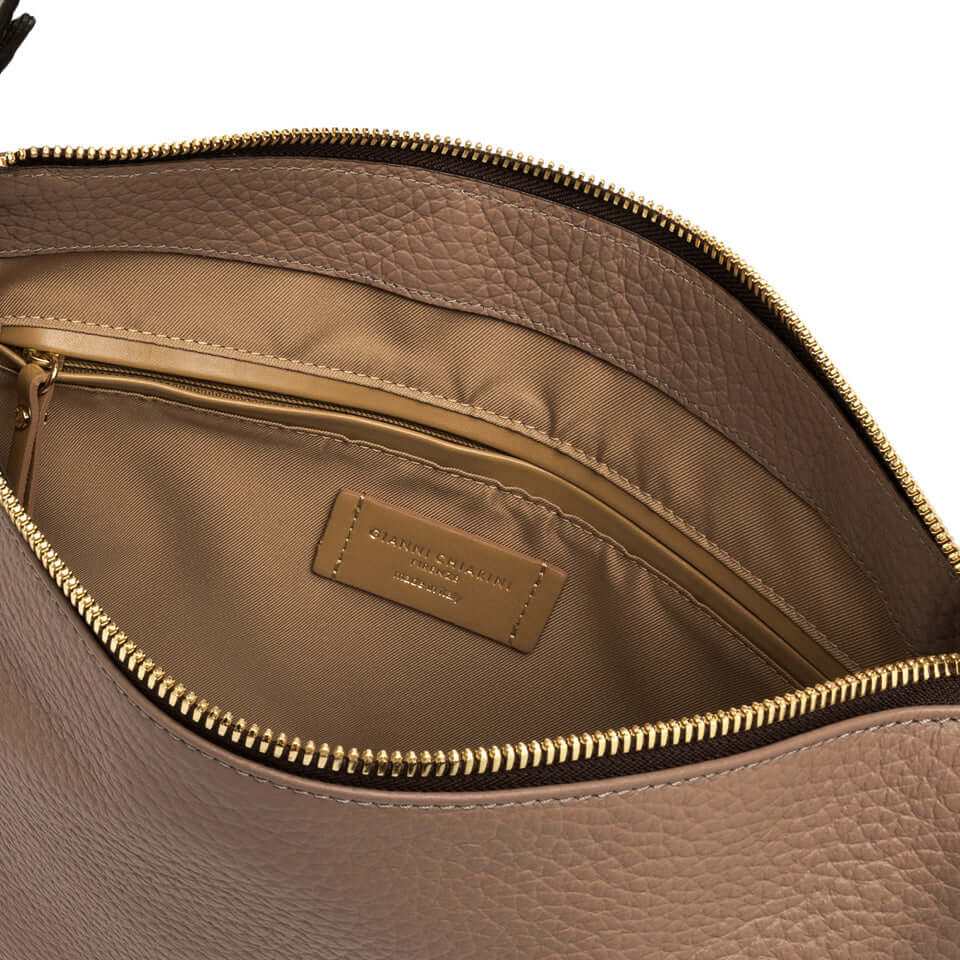 Interior view of the CHIARA bag featuring a zipped pocket and fabric lining in a warm tan color.