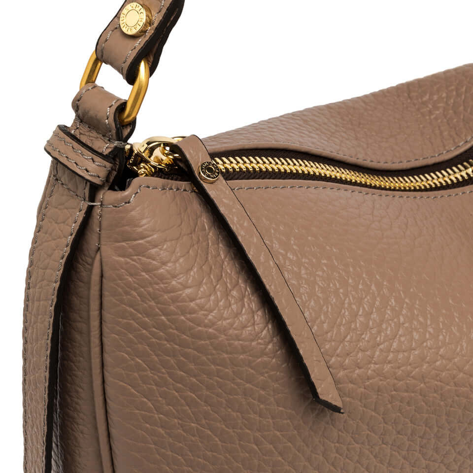 Close-up of Chiara leather bag showing zipper and textured surface in warm beige color.