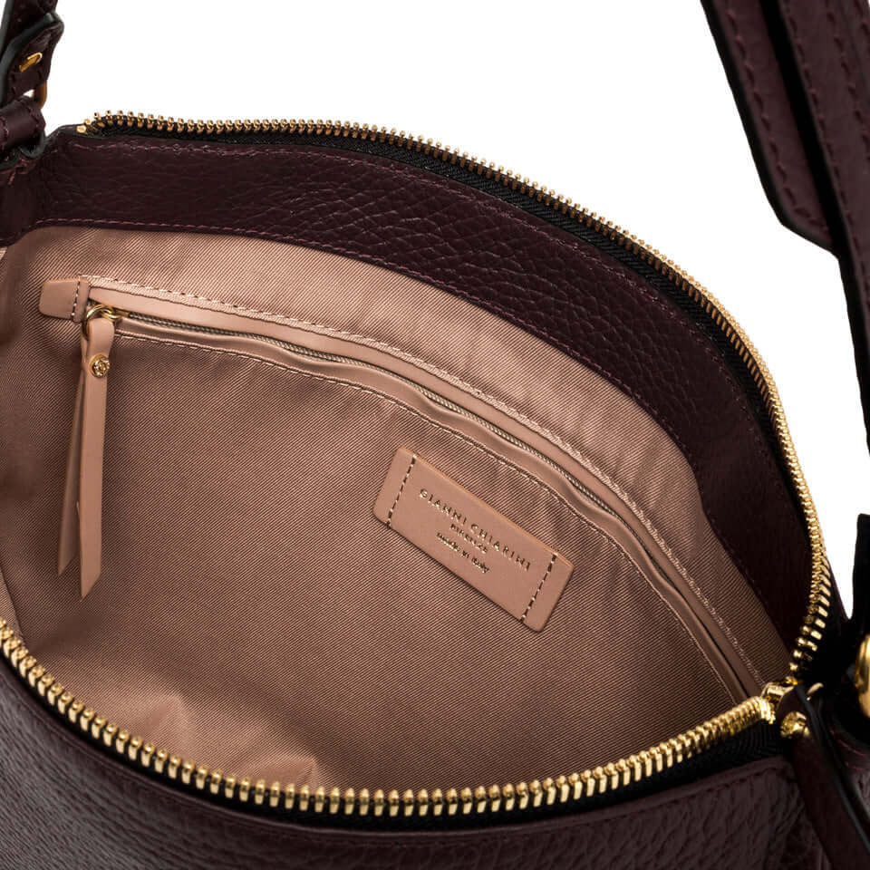 Interior view of the Chiara handbag featuring a zip pocket and fabric lining in a vintage-style design.