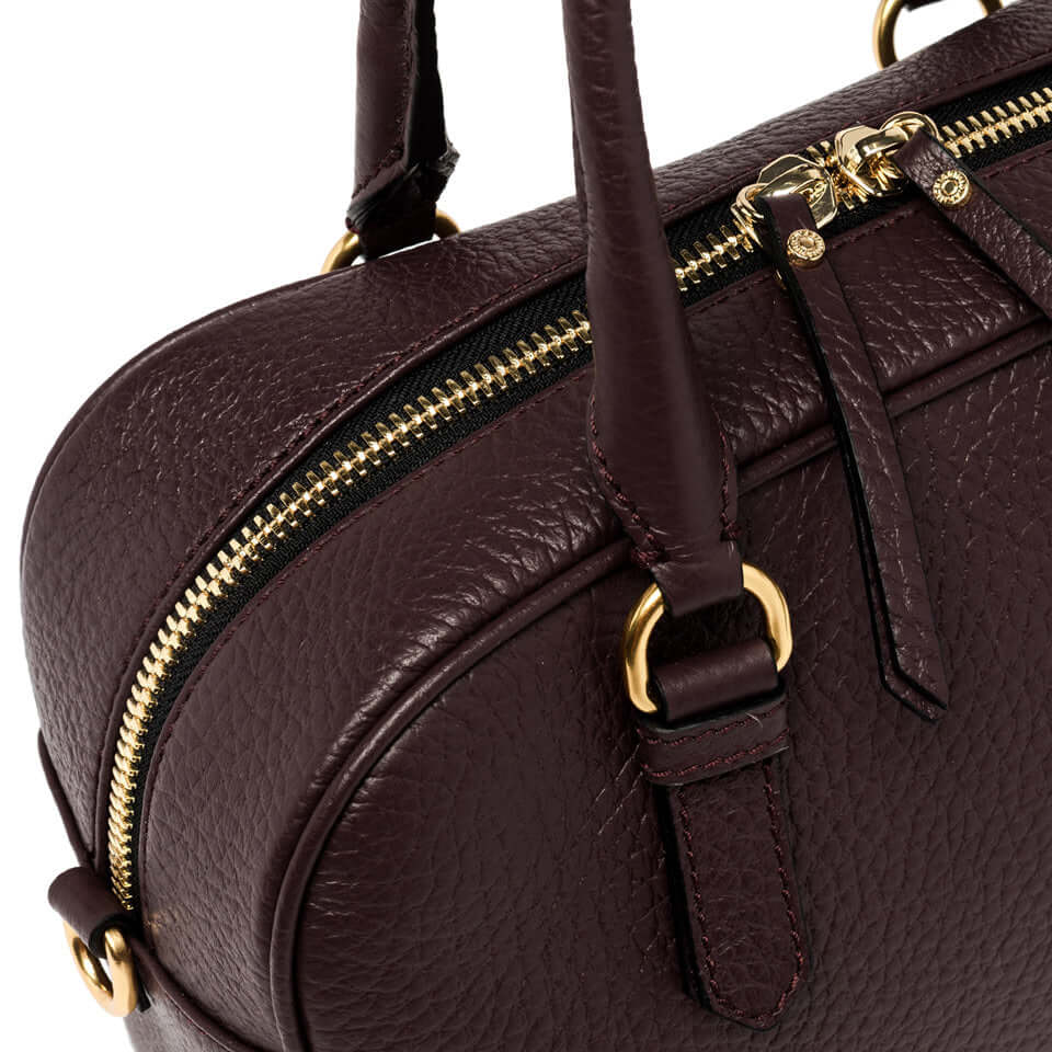 Close-up of the Chiara leather handbag, showcasing its textured surface and golden zipper details.