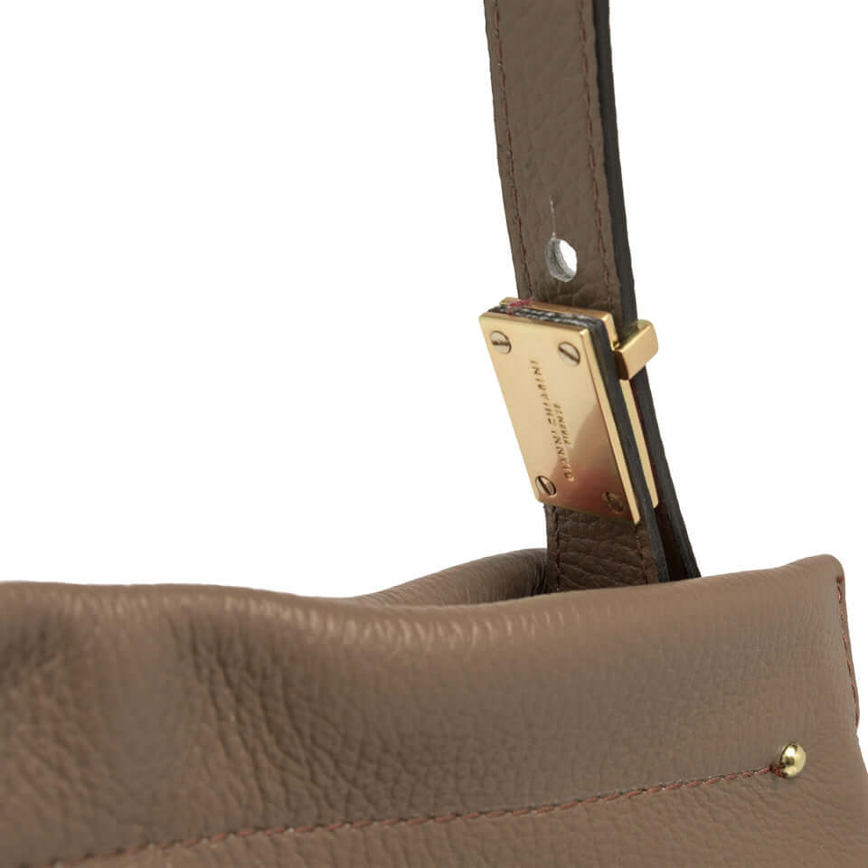 Close-up of Matilde shoulder bag strap featuring gold logo hardware and soft leather texture.