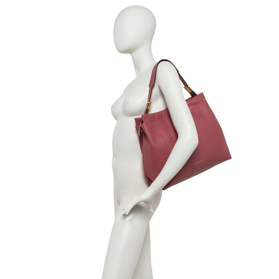 Model showcasing Matilde handbag in soft leather with golden accents and magnetic closure.
