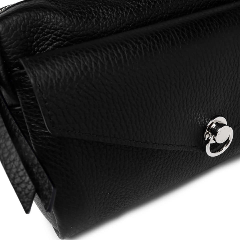 Close-up of the Deva black leather bag with a zip closure and iconic piercing detail.