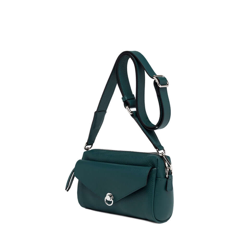 Deva handbag in green leather with removable strap and zip closure, showcasing modern design and practicality.