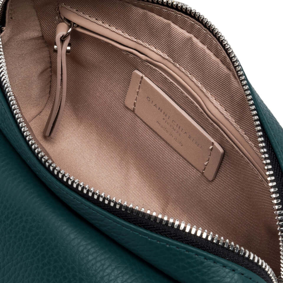 Interior view of Deva handbag showing zip closure and label, featuring luxurious lining in a stylish green leather bag.