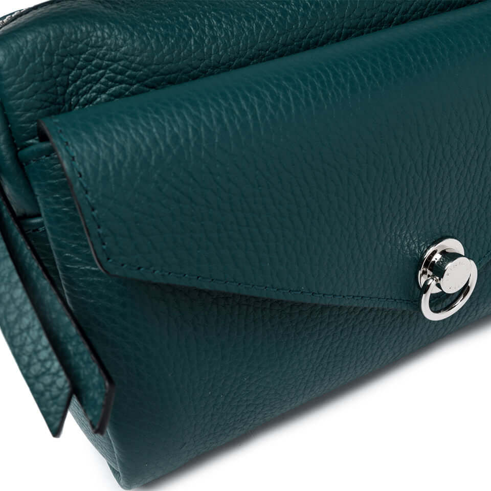 Detail of the Deva handbag in hammered leather, featuring a zip closure and iconic piercing with ring.