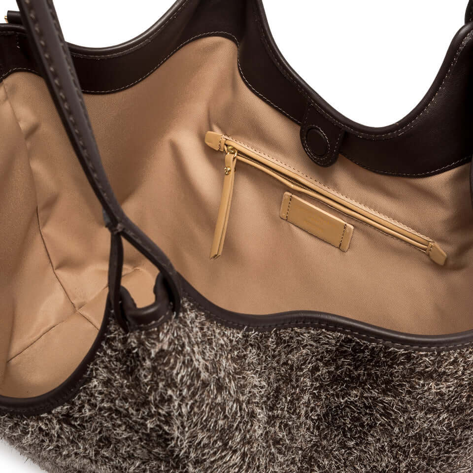 Interior view of a stylish bag featuring a zippered pouch and soft lining, perfect for organizing essentials.