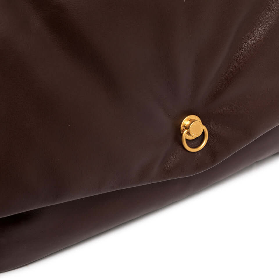 Detail of Mirea pochette in dark brown leather featuring gold logo hardware accent.