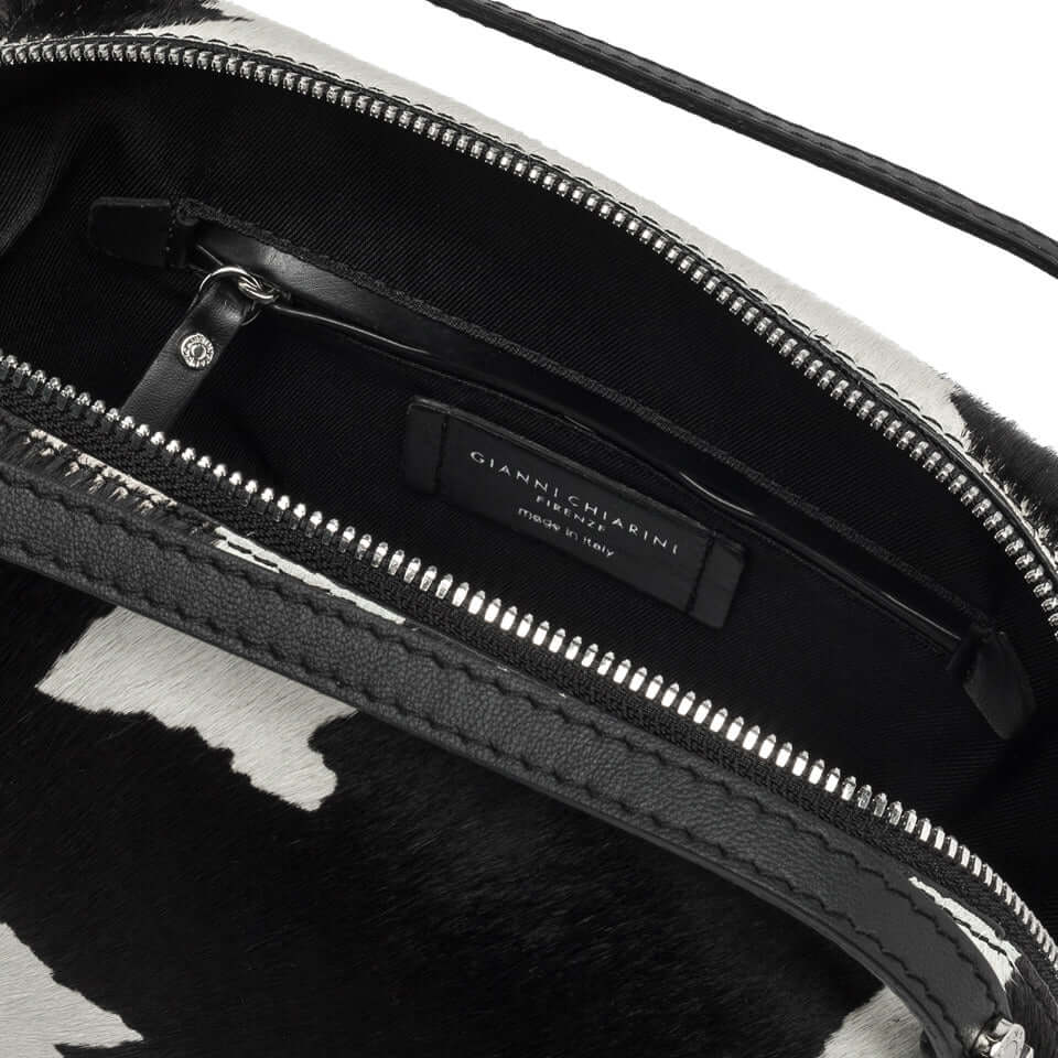 Interior view of the Gianni Chiarini Alifa bag, featuring black leather and cowhide, including zipper pocket and brand label.
