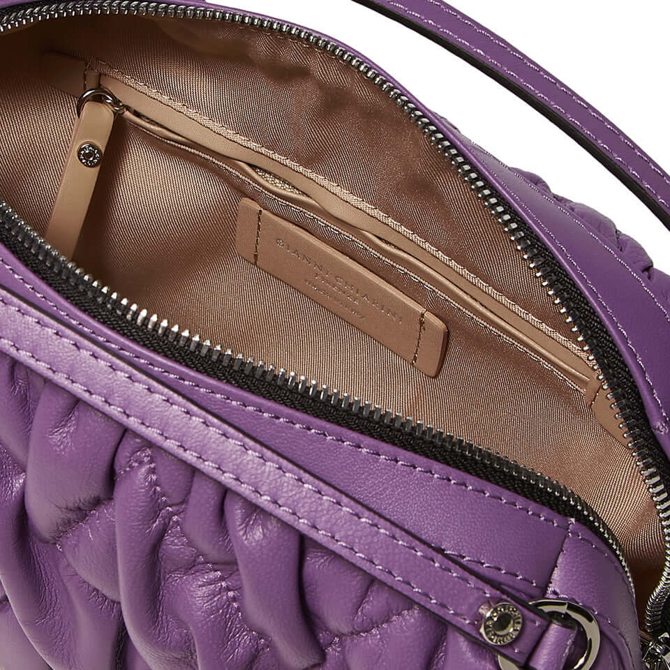 Interior view of a compact purple leather handbag showing its spacious lining and zippered pocket.
