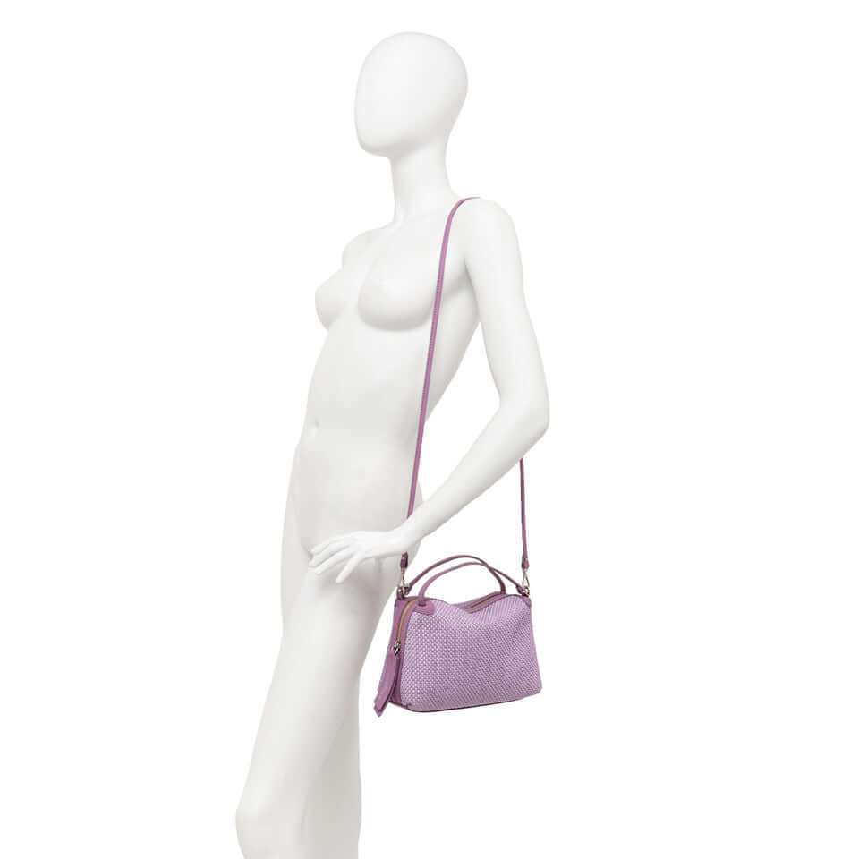 Alifa by Gianni Chiarini, a lightweight woven straw bag, shown on a mannequin with a leather shoulder strap.