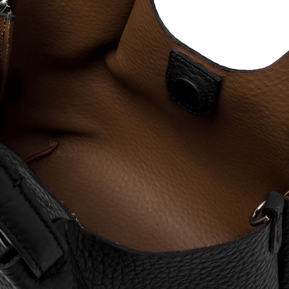 Interno della borsa DUA in pelle, con chiusura magnetica e rivestimento marrone.