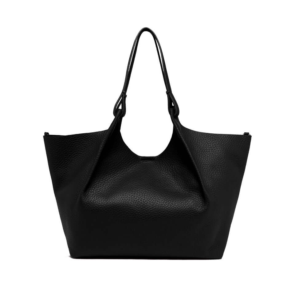 Elegant black leather tote bag by DUA, featuring double grain texture and practical design, perfect for women's outfits.
