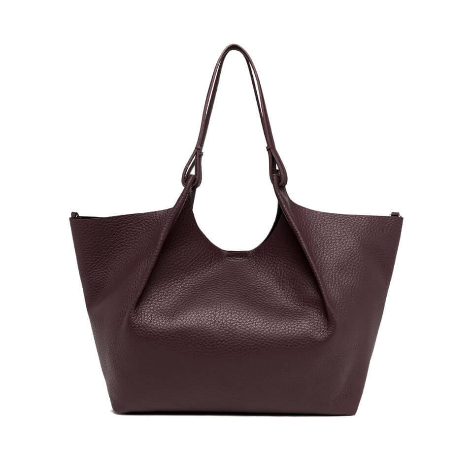 Elegant DUA bag in double-grain leather, featuring two handles and magnet closure. Dimensions: 34x38x16 cm.