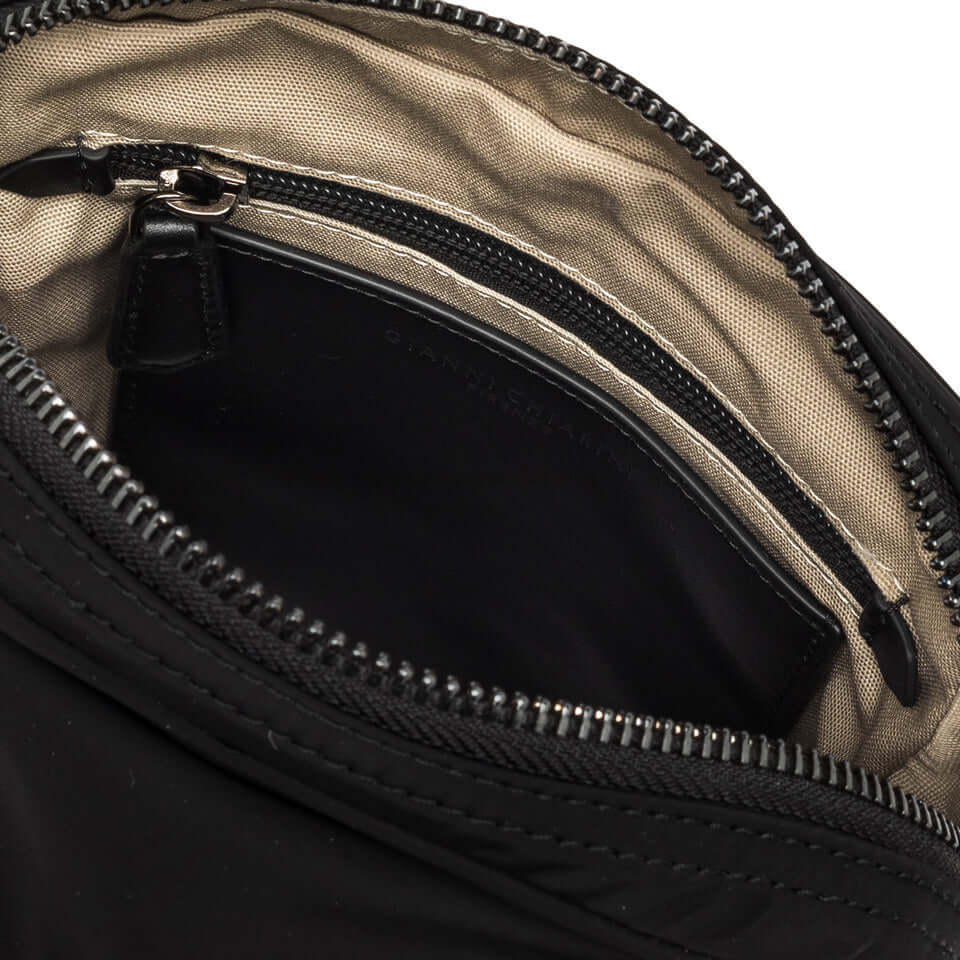 Inside view of the OSLO crossbody bag showing zippered compartment and nylon lining.