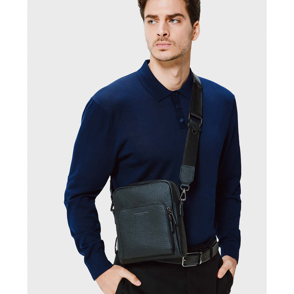 Man wearing a modern crossbody bag in maxi grain leather, perfect for everyday style, featuring adjustable strap.