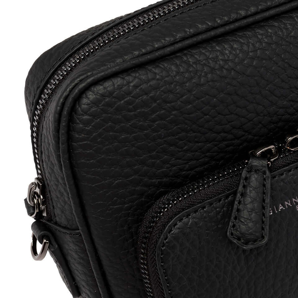 Close-up of FLORENCE black leather shoulder bag with zip closure and front pocket detail.