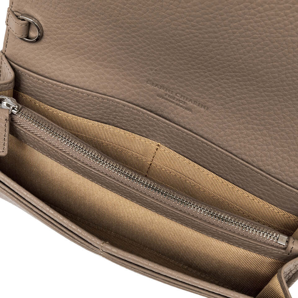 Interno della borsa Deva in pelle martellata, con tasca zip e rivestimento in tessuto chiaro.