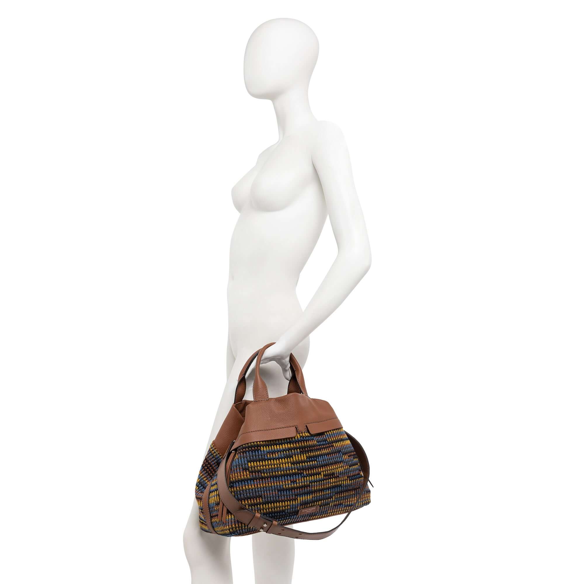 DUNA tote bag with multicolor design and leather accents, featuring zip pockets and adjustable strap.