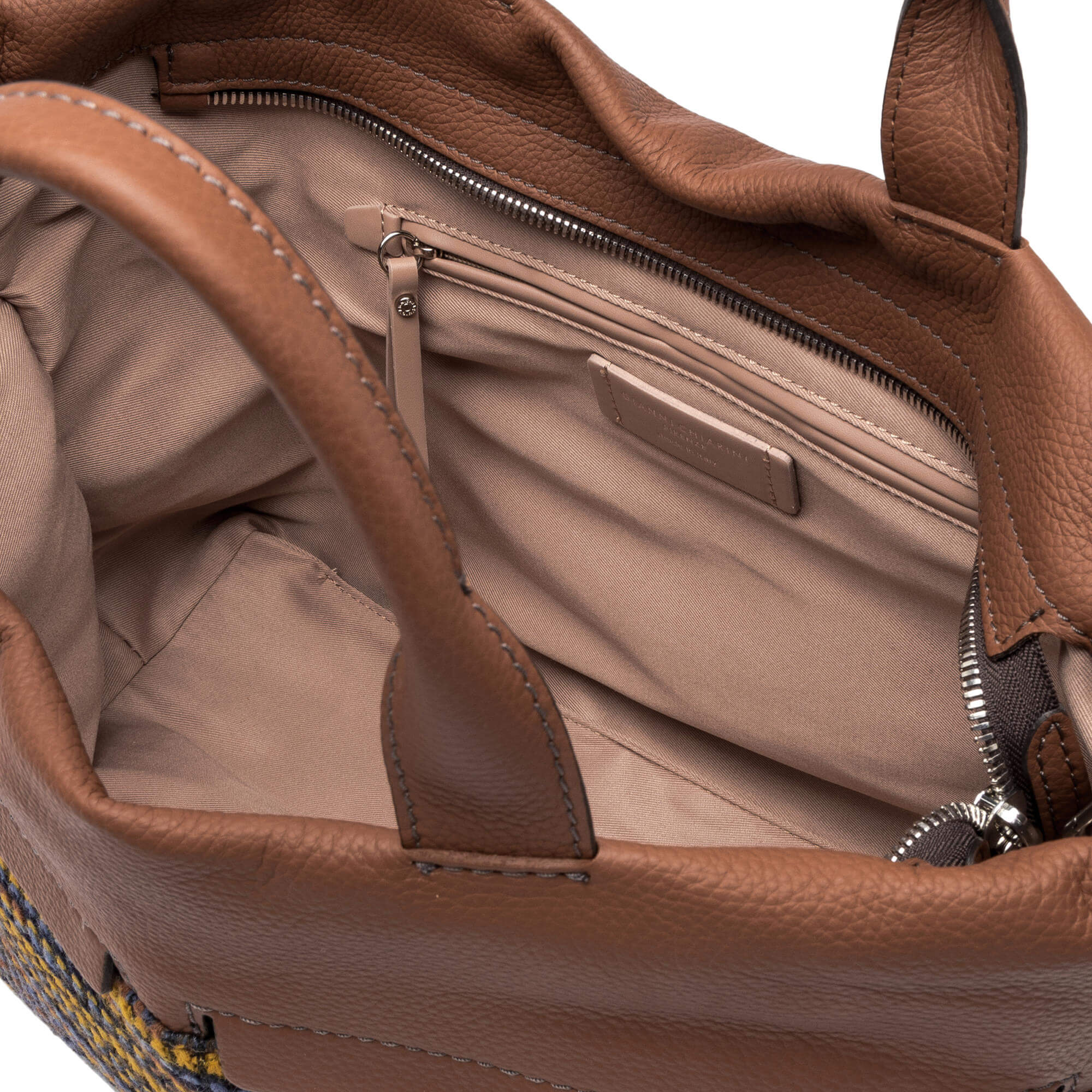 Interior view of the Duna tote bag showcasing leather finish, zip pockets, and organizational spaces.