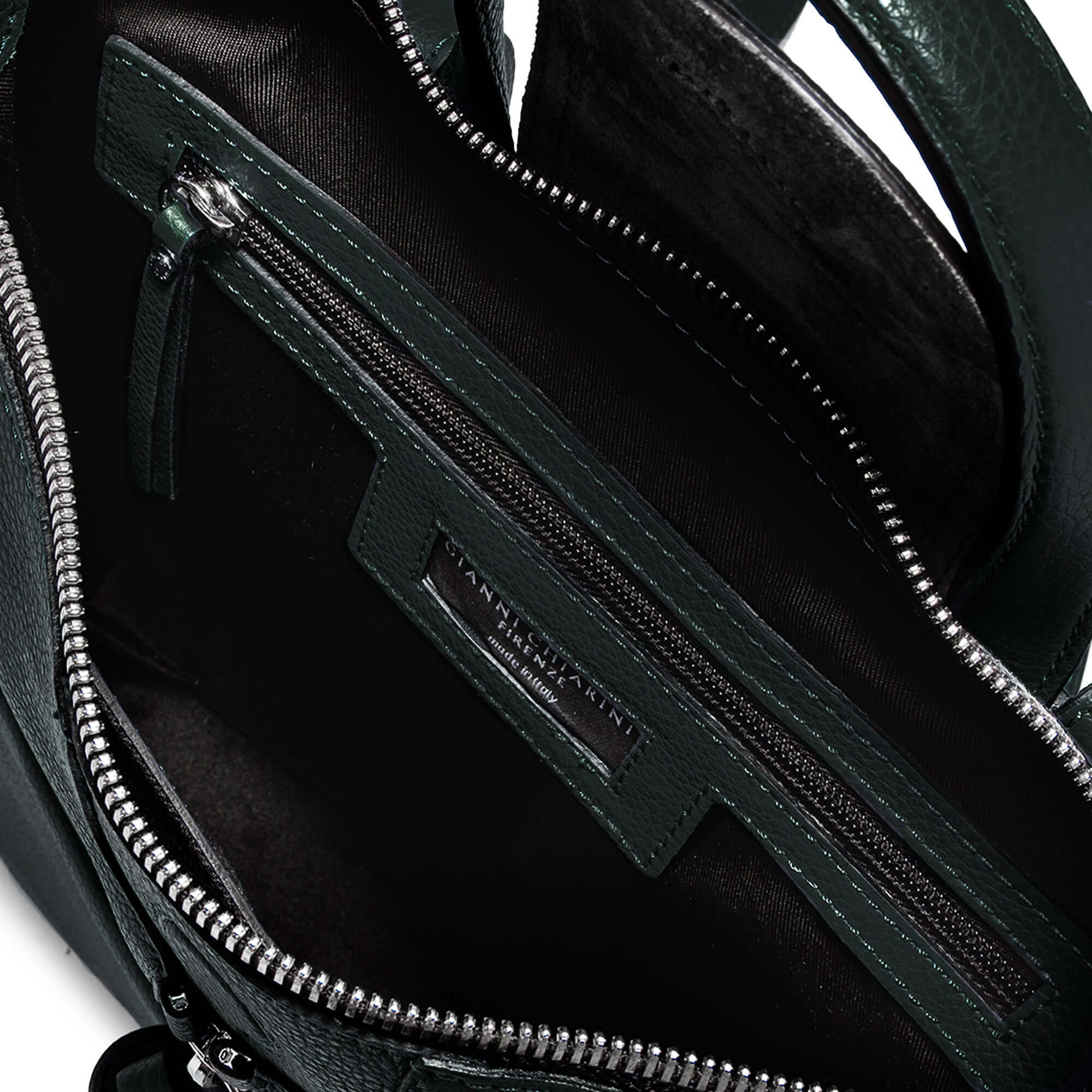 Interior view of the GIADA handbag, featuring zip pockets and soft lining in a stylish green finish.