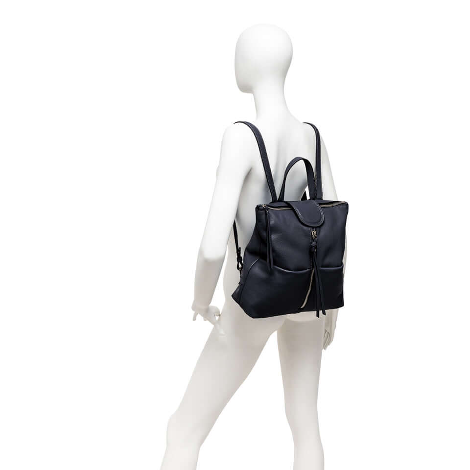 GIADA black leather backpack on a mannequin, featuring adjustable straps, front zip closure, and multiple pockets.