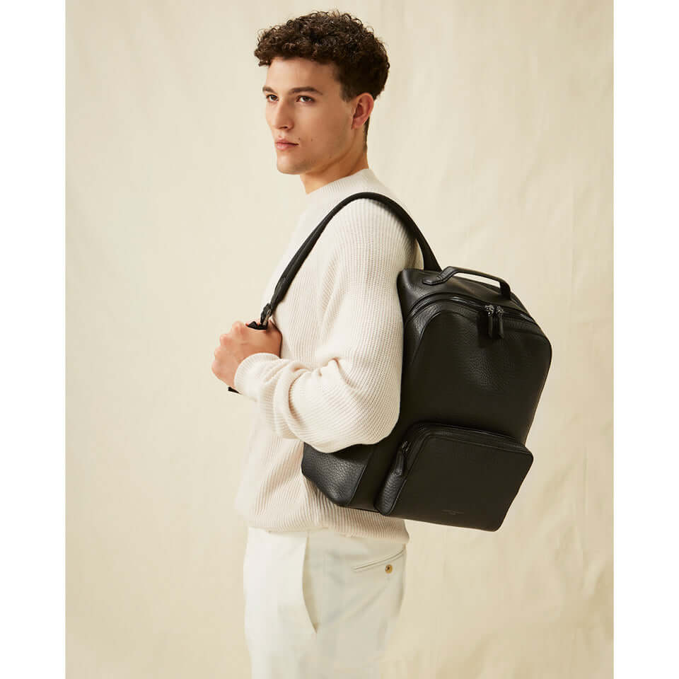 Model wearing the FLORENCE black backpack by Gianni Chiarini Firenze, showcasing its minimalist design and functionality.