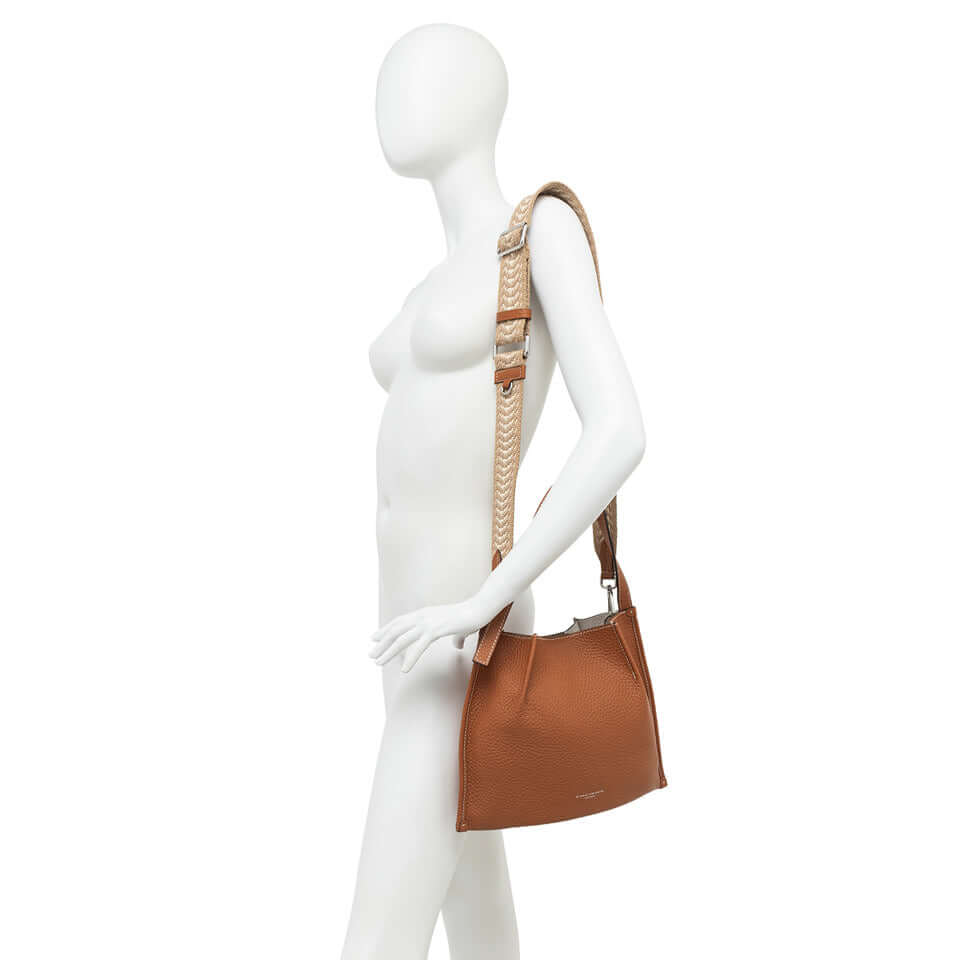 Dory handbag in light brown with braided strap, showcasing a casual and stylish design on a mannequin.