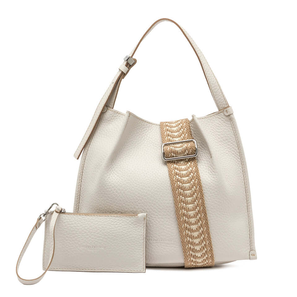 Dory bag in light leather with a stylish strap, featuring a magnetic button closure and a matching pouch.