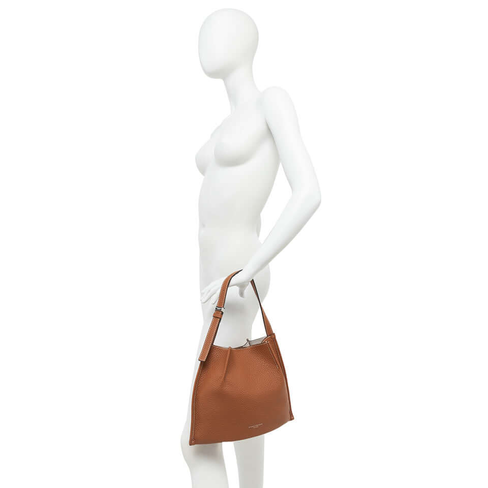 Dory handbag in brown leather, featuring simple design and adjustable twin logo passants.