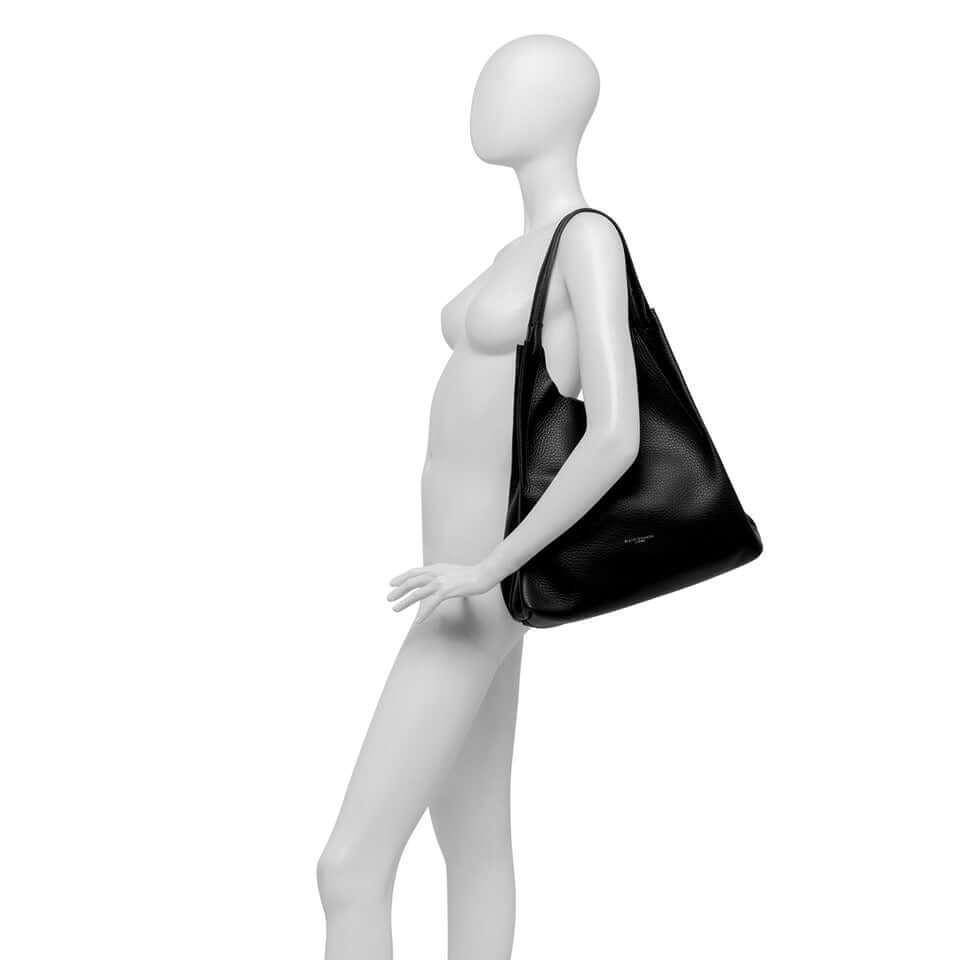 Black DUA handbag on minimalist mannequin, showcasing contemporary design and double grain leather texture.