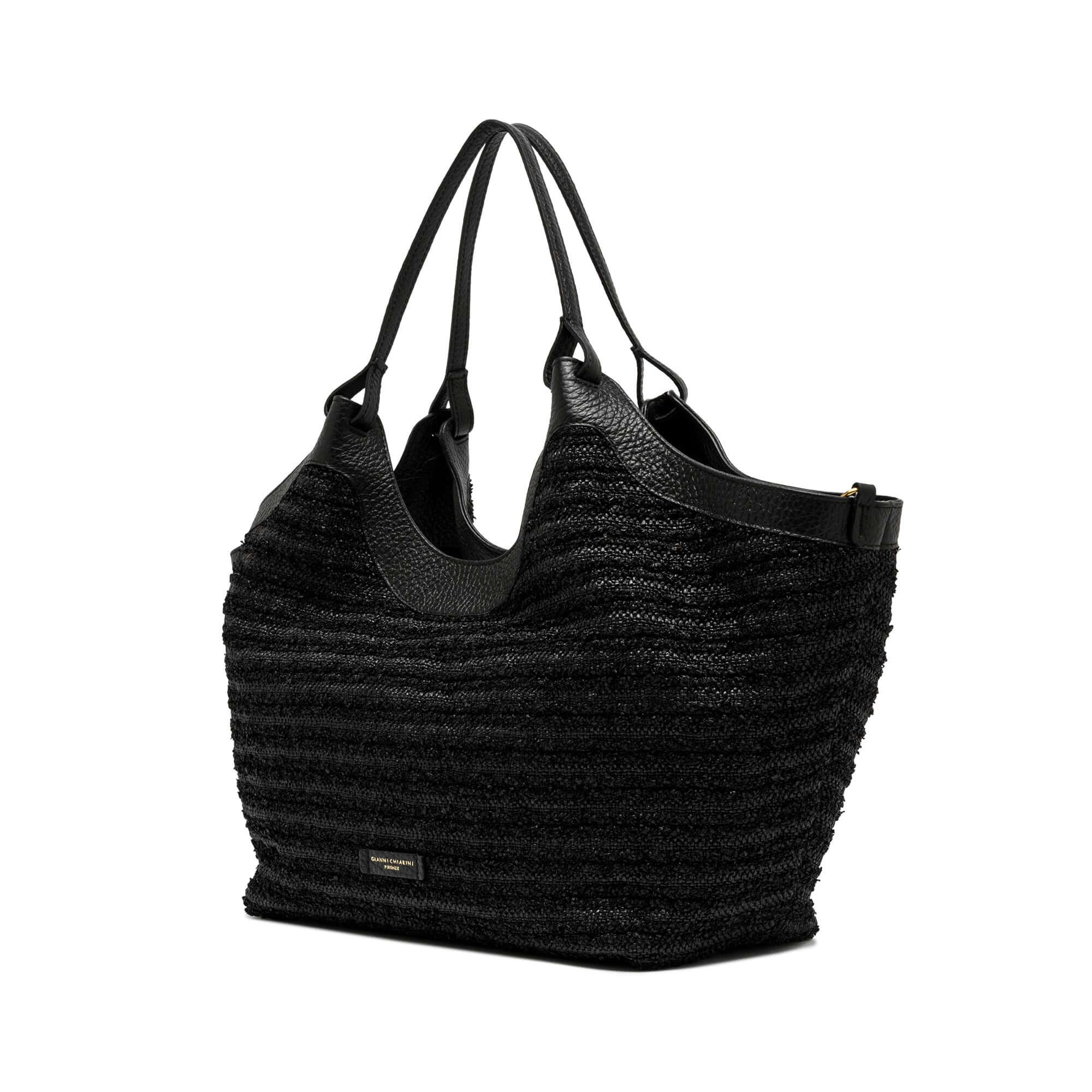 Black straw tote bag with leather handles, spacious design and zipped pouch, perfect for any outfit.